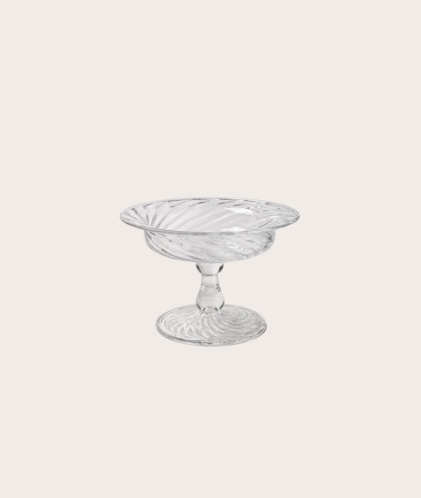 Clear glass compote on a light gray background
