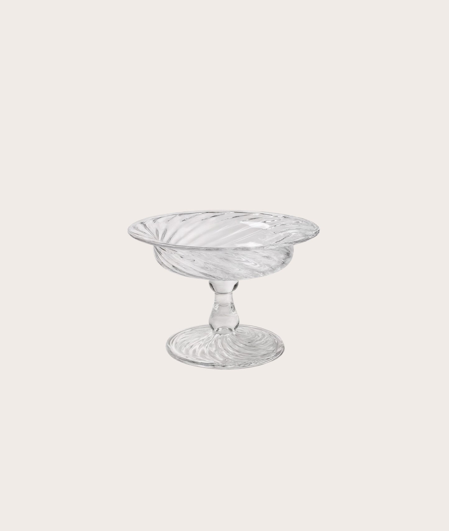 Clear glass compote on a light gray background